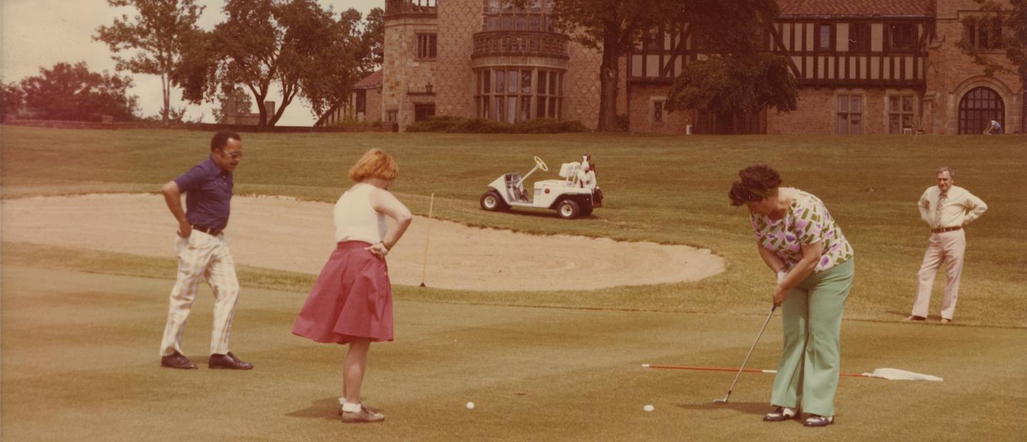 A historic photo of people putting on a golf course